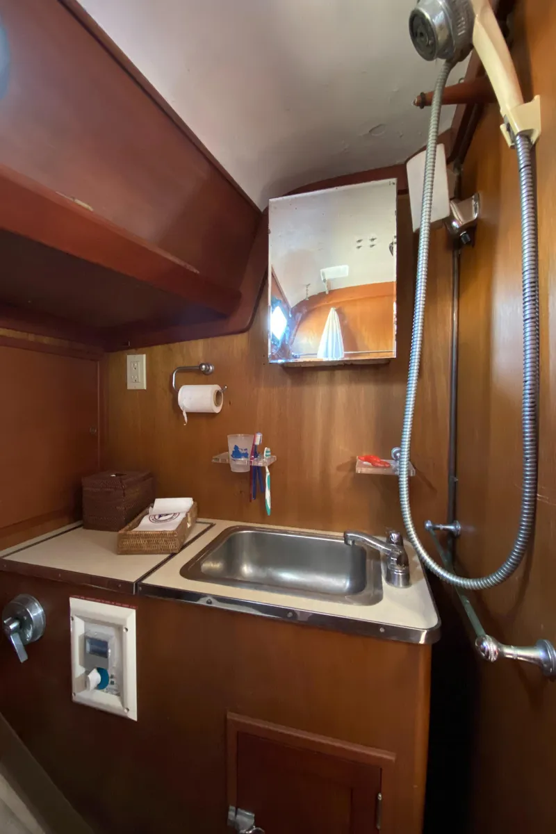 Slide: The Image of Hinckley Bermuda 40 (1962) yacht bathroom with sink, mirror, and showerhead. - 16