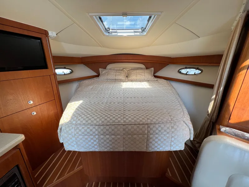 Slide: The Image of 2004 Tiara Yachts 3200 Open cabin with bed, skylight, and wooden cabinetry. - 17