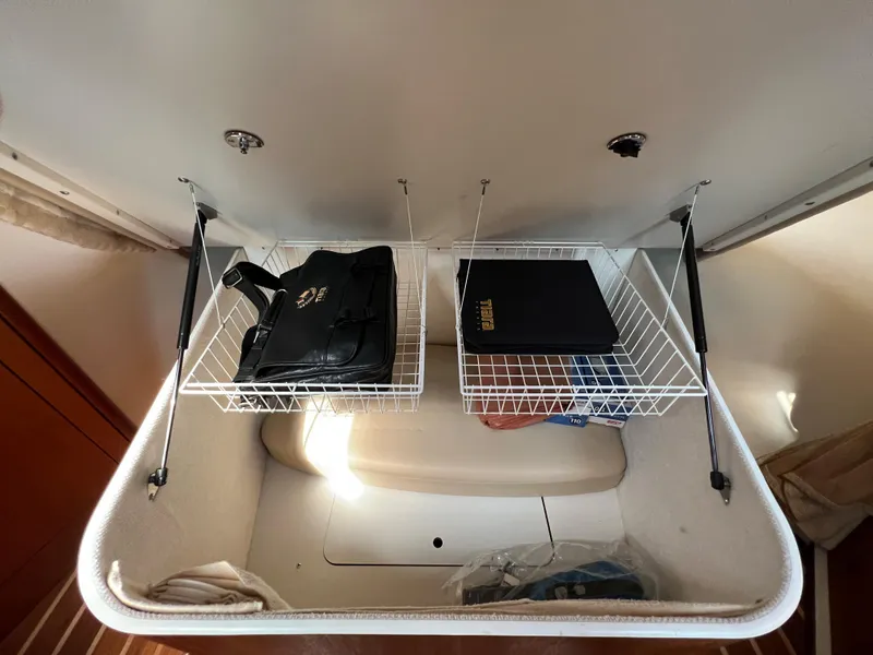 Slide: The Image of Storage compartment in 2004 Tiara Yachts 3200 Open with wire shelves and bags. - 18