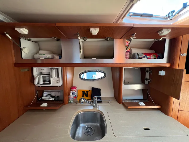 Slide: The Image of 2004 Tiara Yachts 3200 Open kitchen with sink, storage cabinets, and appliances. - 20
