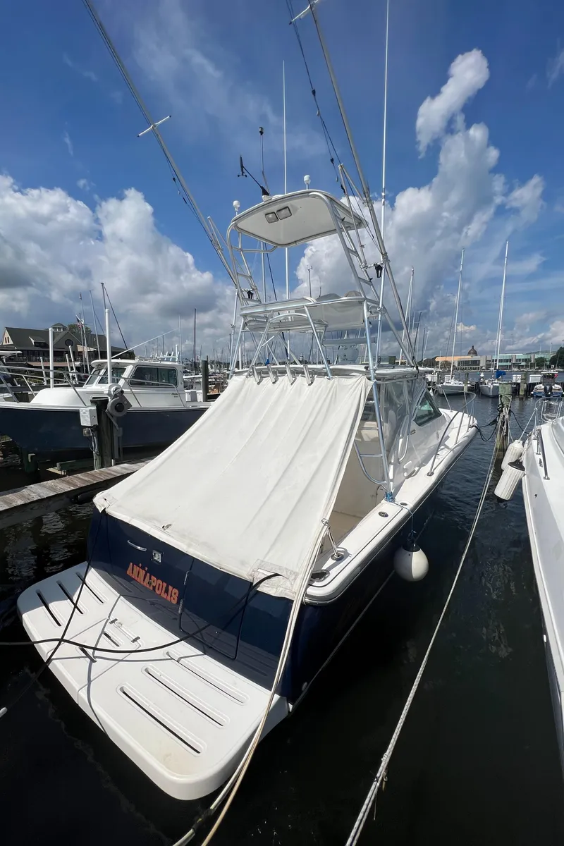 Slide: The Image of 2004 Tiara Yachts 3200 Open docked at a marina under a blue sky. - 4