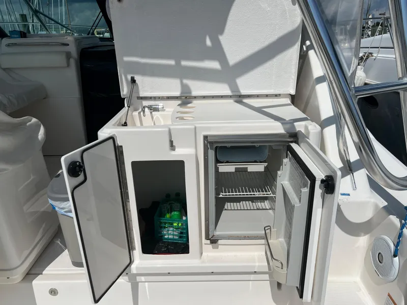 Slide: The Image of 2004 Tiara Yachts 3200 Open galley with open storage and mini-fridge. - 8