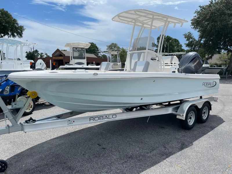 Slide: The Image of 2024 Robalo 206 Cayman boat on a trailer in a parking lot. - 0