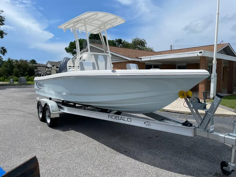 Slide: The Image of 2024 Robalo 206 Cayman boat on a trailer in a residential area. - 1