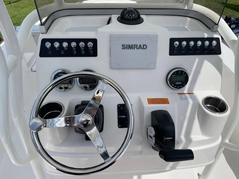 Slide: The Image of 2024 Robalo 206 Cayman boat dashboard with Simrad display and steering wheel. - 9