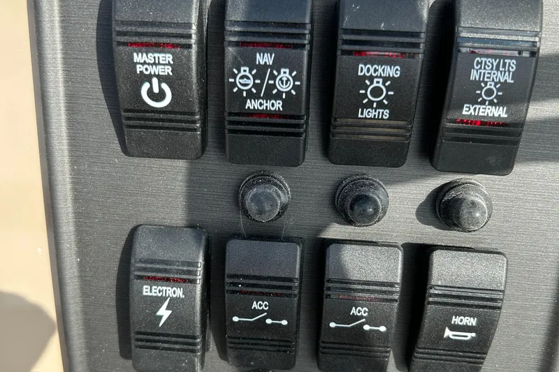 Slide: The Image of Control panel switches of a 2024 Bentley Pontoons LE 180 CR boat. - 11