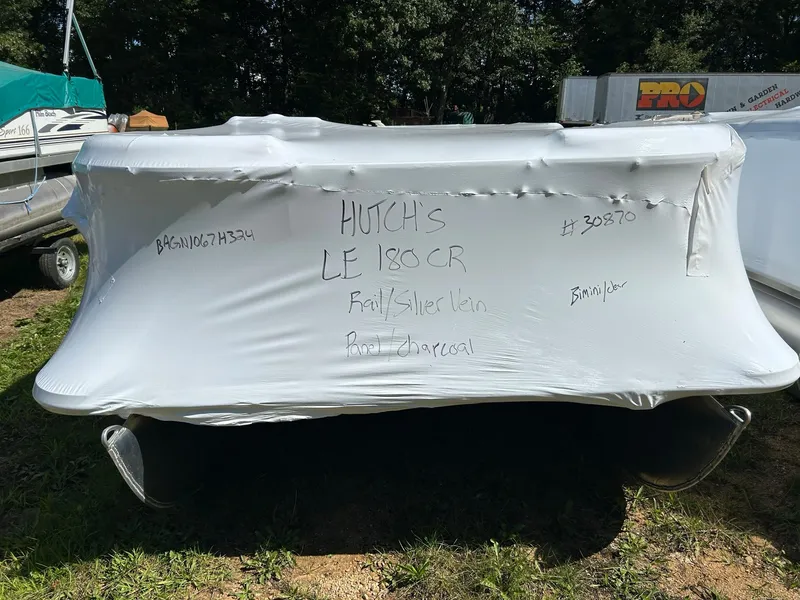 Slide: The Image of 2024 Bentley Pontoons LE 180 CR covered in protective wrap, parked outdoors. - 14