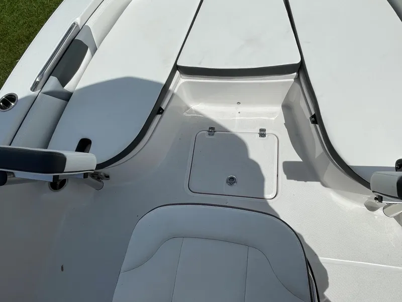 Slide: The Image of 2024 Robalo 226 Cayman boat interior, white seating and storage compartment. - 11