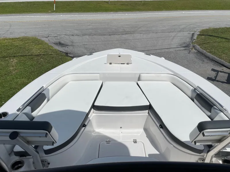 Slide: The Image of 2024 Robalo 226 Cayman boat bow seating area with white cushions. - 9