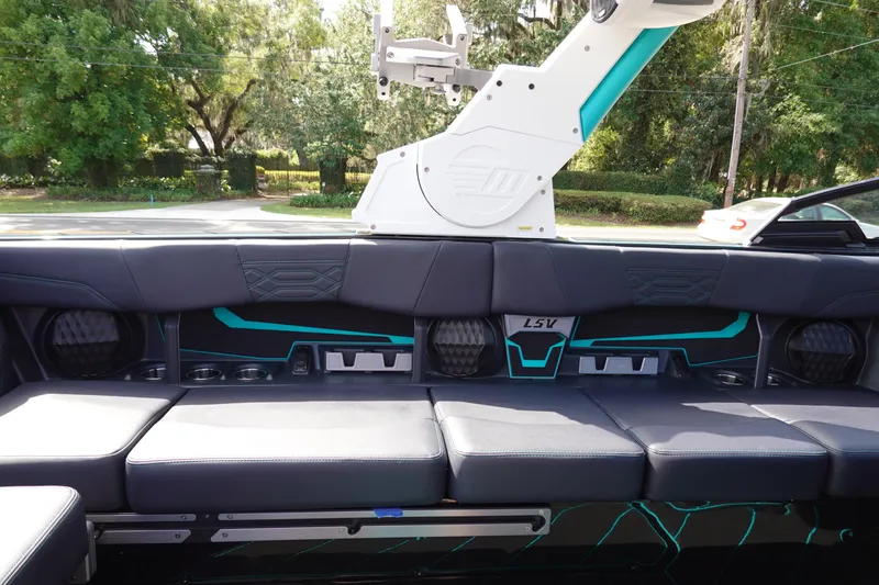 Slide: The Image of 2023 Malibu 25 LSV boat interior with black and teal seating and advanced sound system. - 17