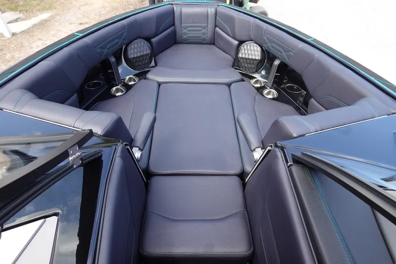 Slide: The Image of 2023 Malibu 25 LSV boat interior with luxurious seating and cup holders. - 22