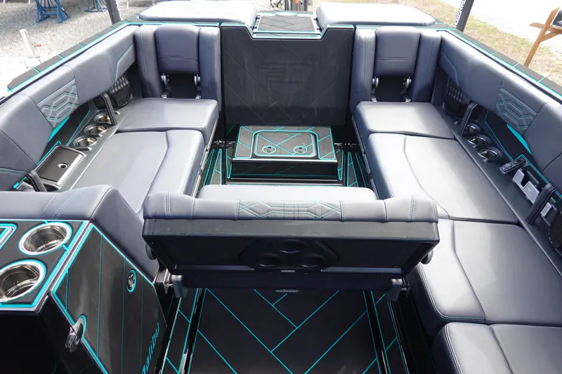 Slide: The Image of 2023 Malibu 25 LSV boat interior with luxurious seating and cup holders. - 23