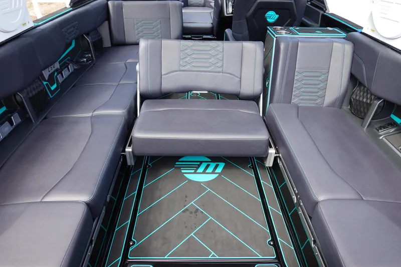 Slide: The Image of 2023 Malibu 25 LSV boat interior with black and teal seating and flooring. - 24