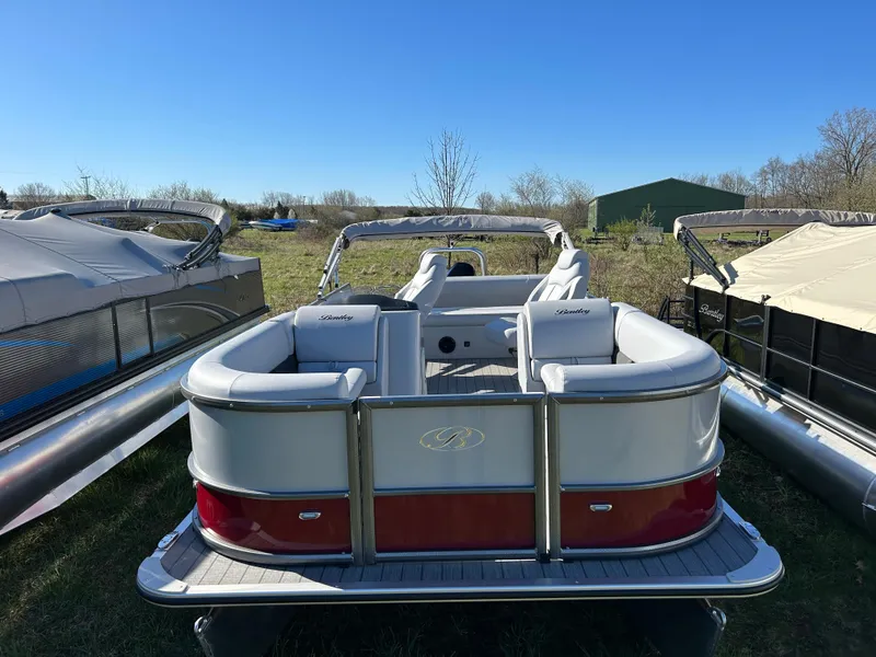 Slide: The Image of 2024 Bentley Pontoons Legacy Swingback 220 pontoon boat in a marina. - 1