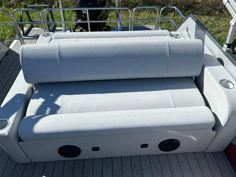 Slide: The Image of 2024 Bentley Pontoons Legacy Swingback 220 rear seating area with cup holders and speakers. - 12
