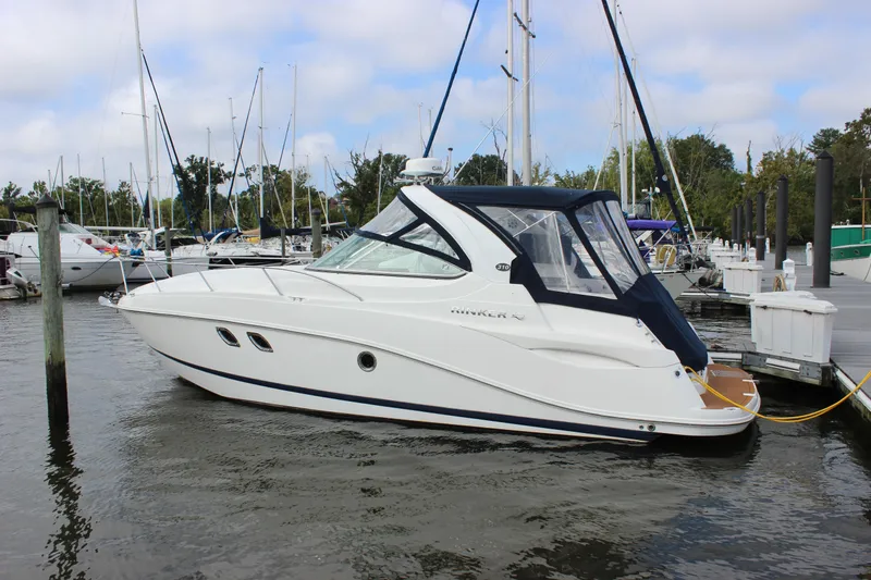 Slide: The Image of 2011 Rinker 310 Express Cruiser docked at a marina. - 10