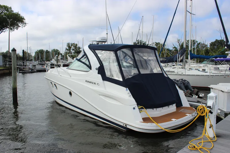 Slide: The Image of 2011 Rinker 310 Express Cruiser docked at a marina. - 11
