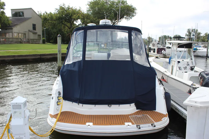 Slide: The Image of 2011 Rinker 310 Express Cruiser docked at a marina. - 12