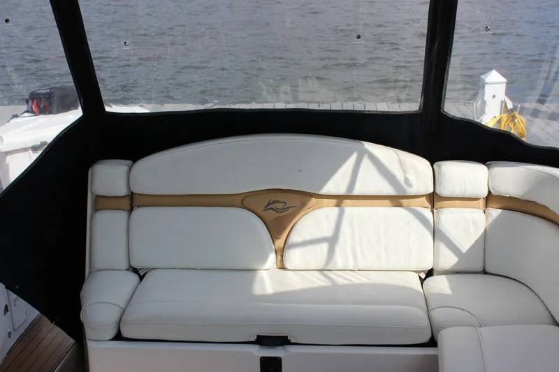 Slide: The Image of 2011 Rinker 310 Express Cruiser interior seating with white and tan upholstery. - 14
