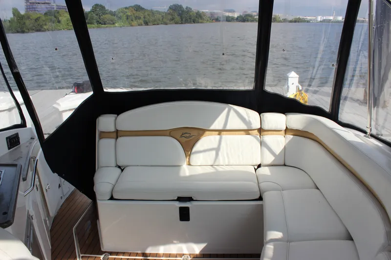 Slide: The Image of 2011 Rinker 310 Express Cruiser interior with white seating and lake view. - 15
