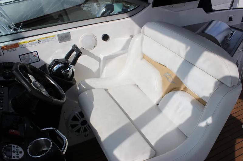 Slide: The Image of Captain's seat and helm of a 2011 Rinker 310 Express Cruiser. - 17
