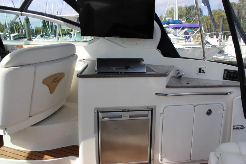 Slide: The Image of 2011 Rinker 310 Express Cruiser interior with kitchenette and seating area. - 20