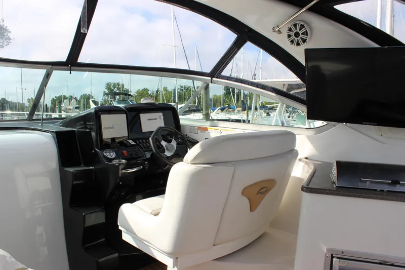 Slide: The Image of 2011 Rinker 310 Express Cruiser helm with white captain's seat and navigation equipment. - 21