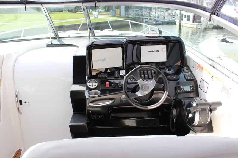 Slide: The Image of 2011 Rinker 310 Express Cruiser helm with Garmin and Mercury displays. - 22