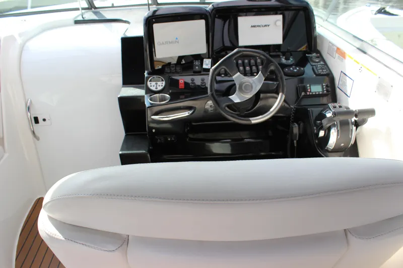 Slide: The Image of 2011 Rinker 310 Express Cruiser helm with Garmin and Mercury controls. - 23