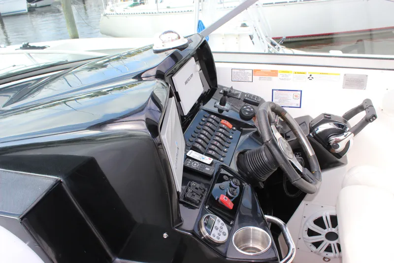 Slide: The Image of 2011 Rinker 310 Express Cruiser helm with steering wheel, controls, and navigation equipment. - 28