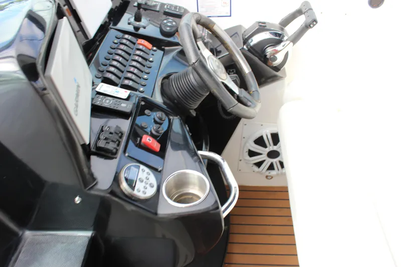 Slide: The Image of 2011 Rinker 310 Express Cruiser helm with steering wheel and control panel. - 29
