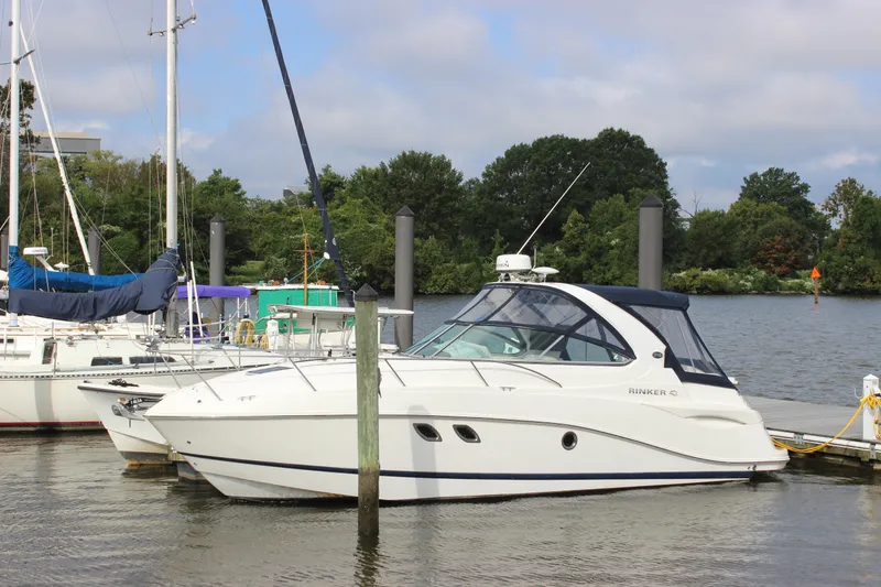 Slide: The Image of 2011 Rinker 310 Express Cruiser docked at a marina. - 3