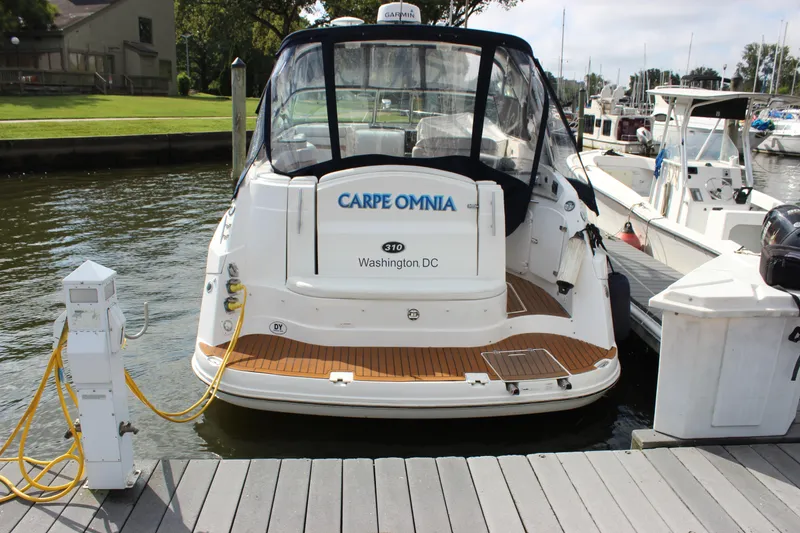 Slide: The Image of 2011 Rinker 310 Express Cruiser docked at marina, rear view. - 31