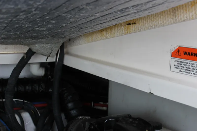 Slide: The Image of Engine compartment of a 2011 Rinker 310 Express Cruiser with visible wiring and warning label. - 42