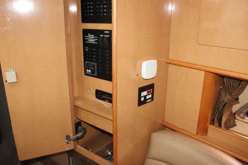 Slide: The Image of 2011 Rinker 310 Express Cruiser interior control panel and storage. - 45