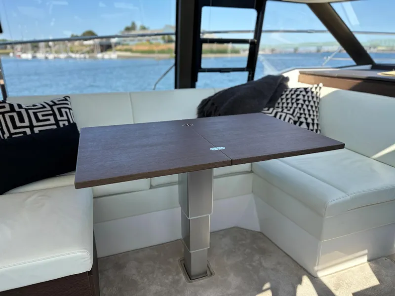 Slide: The Image of Interior of 2021 Prestige 420 S yacht with a wooden table and white seating. - 25