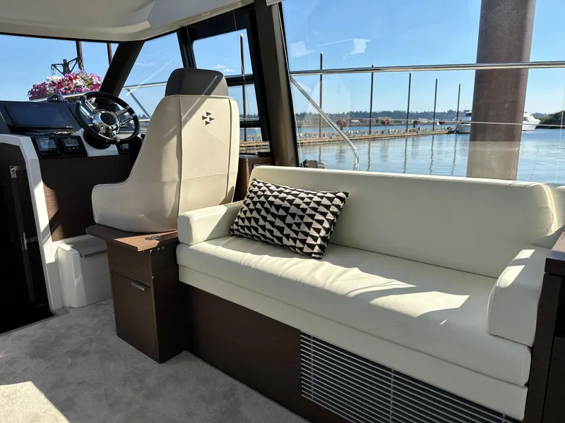 Slide: The Image of Interior of a 2021 Prestige 420 S yacht with a white sofa and geometric pillow. - 27