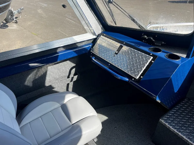 Slide: The Image of Interior of 2024 Thunder Jet 22 Alexis OS boat with white seating and blue dashboard. - 10