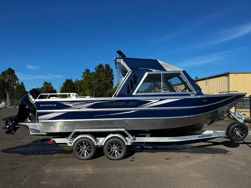 Slide: The Image of 2024 Thunder Jet 22 Alexis OS boat on a trailer under a clear blue sky. - 2