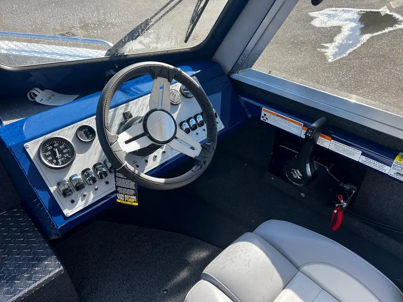 Slide: The Image of 2024 Thunder Jet 22 Alexis OS boat cockpit with steering wheel and control panel. - 9