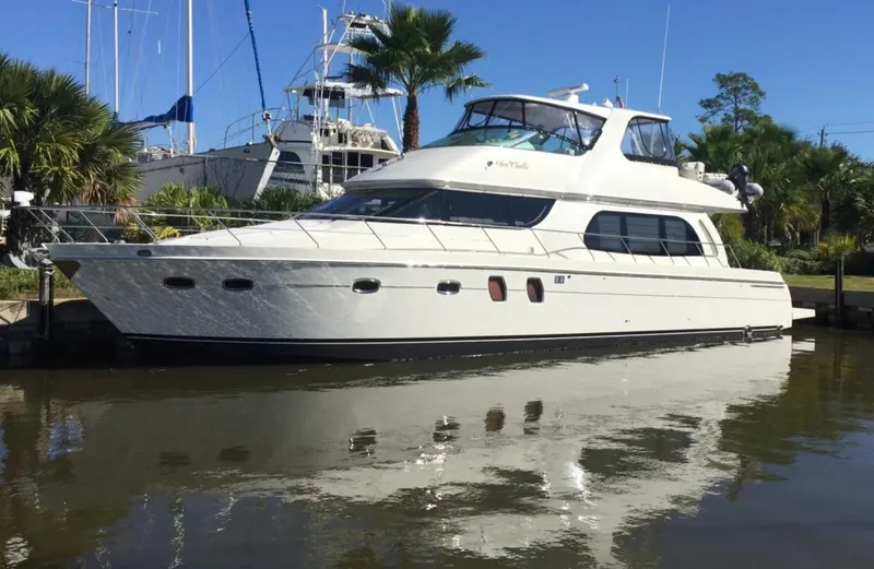 The Image of 2007 Carver 56 Voyager yacht docked in a marina, surrounded by palm trees and clear blue sky. - 0