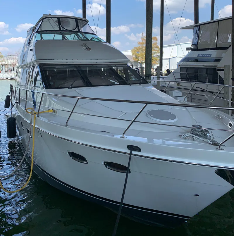 Slide: The Image of 2007 Carver 56 Voyager yacht docked in marina, under clear blue sky. - 10