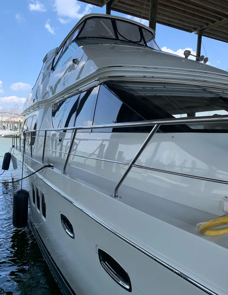 Slide: The Image of 2007 Carver 56 Voyager yacht docked under a canopy with clear blue skies. - 11