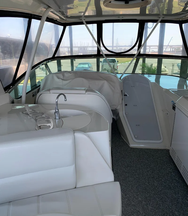Slide: The Image of 2007 Carver 56 Voyager interior with white seating, sink, and panoramic windows. - 32
