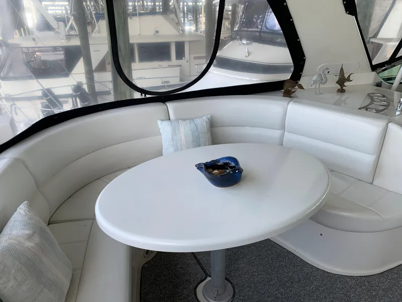 Slide: The Image of 2007 Carver 56 Voyager yacht interior with white seating and table, featuring decorative items. - 43