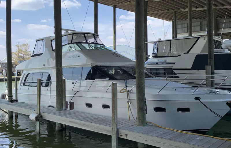 Slide: The Image of 2007 Carver 56 Voyager yacht docked in a marina under a covered shelter. - 6