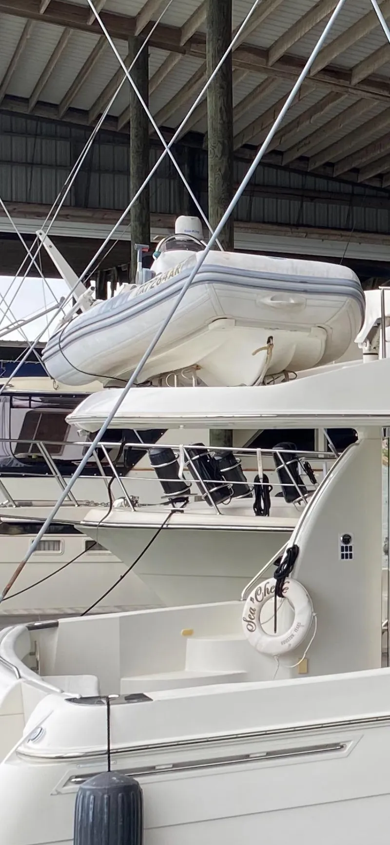 Slide: The Image of 2007 Carver 56 Voyager yacht docked with inflatable boat on top. - 7