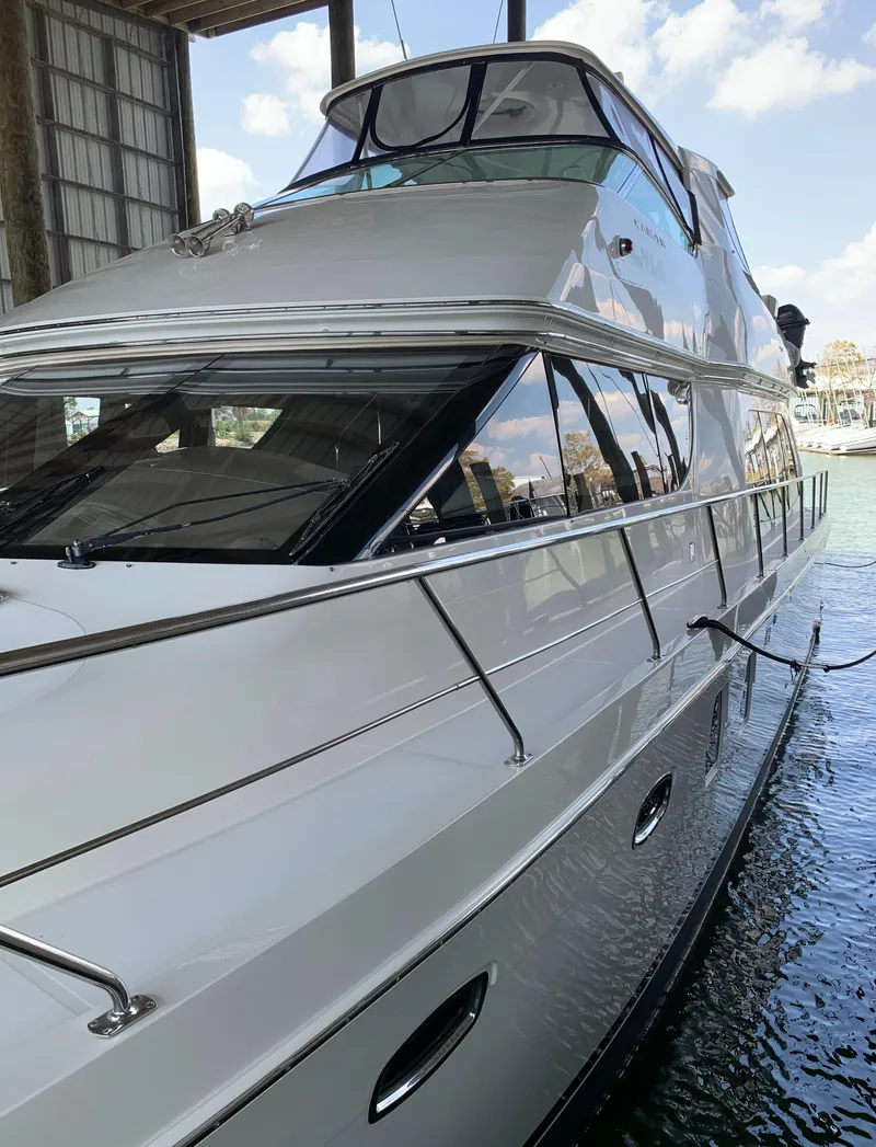 Slide: The Image of 2007 Carver 56 Voyager yacht docked in a marina, showcasing sleek design and luxury features. - 12