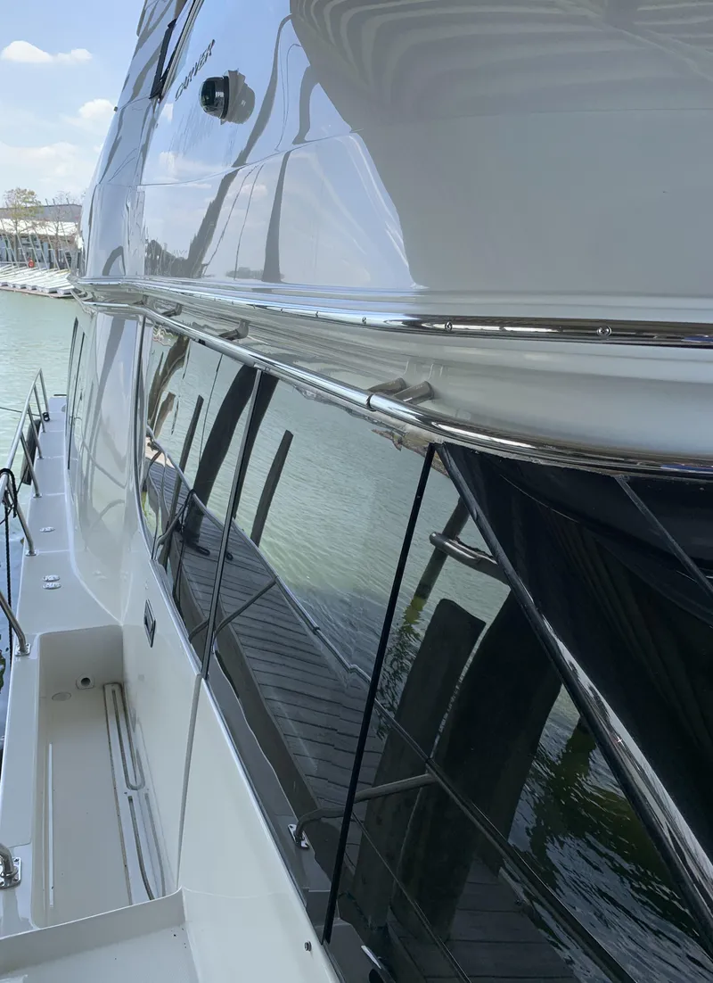 Slide: The Image of 2007 Carver 56 Voyager yacht side view, docked on calm water. - 14