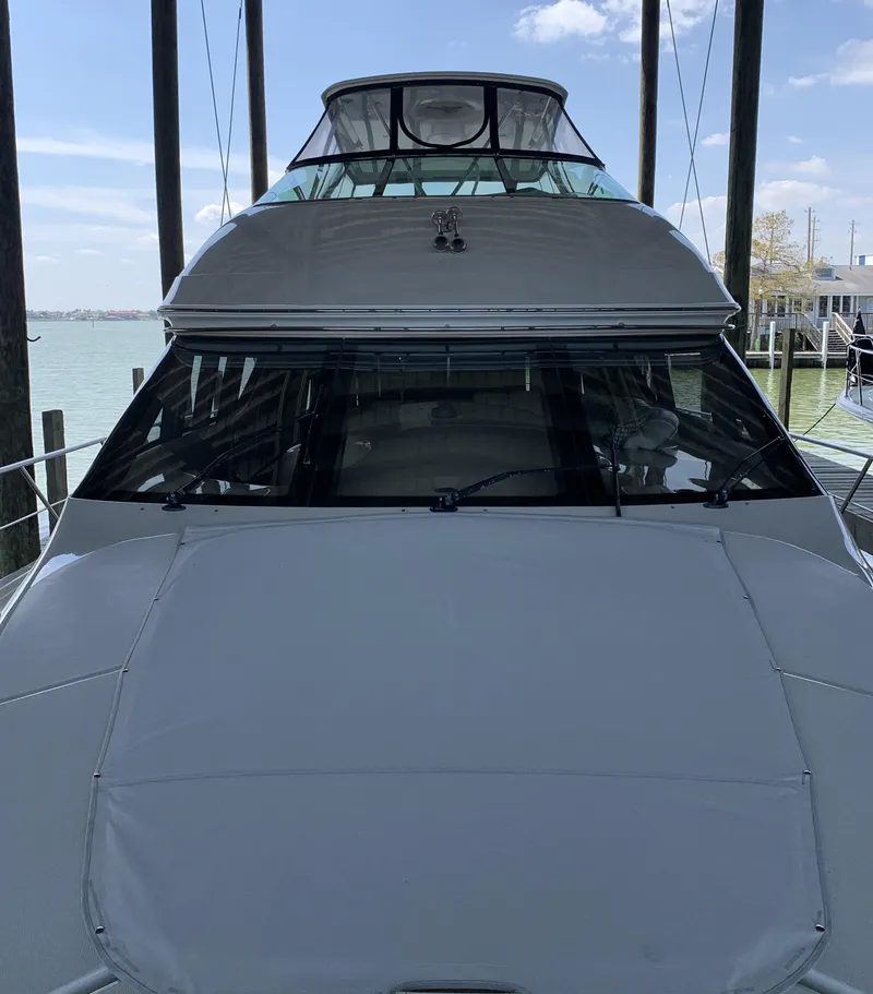 Slide: The Image of 2007 Carver 56 Voyager yacht docked, showcasing sleek design and spacious upper deck. - 16